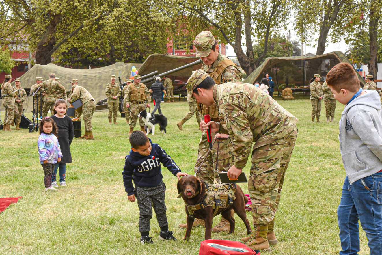 perrito y niño juegan con militar