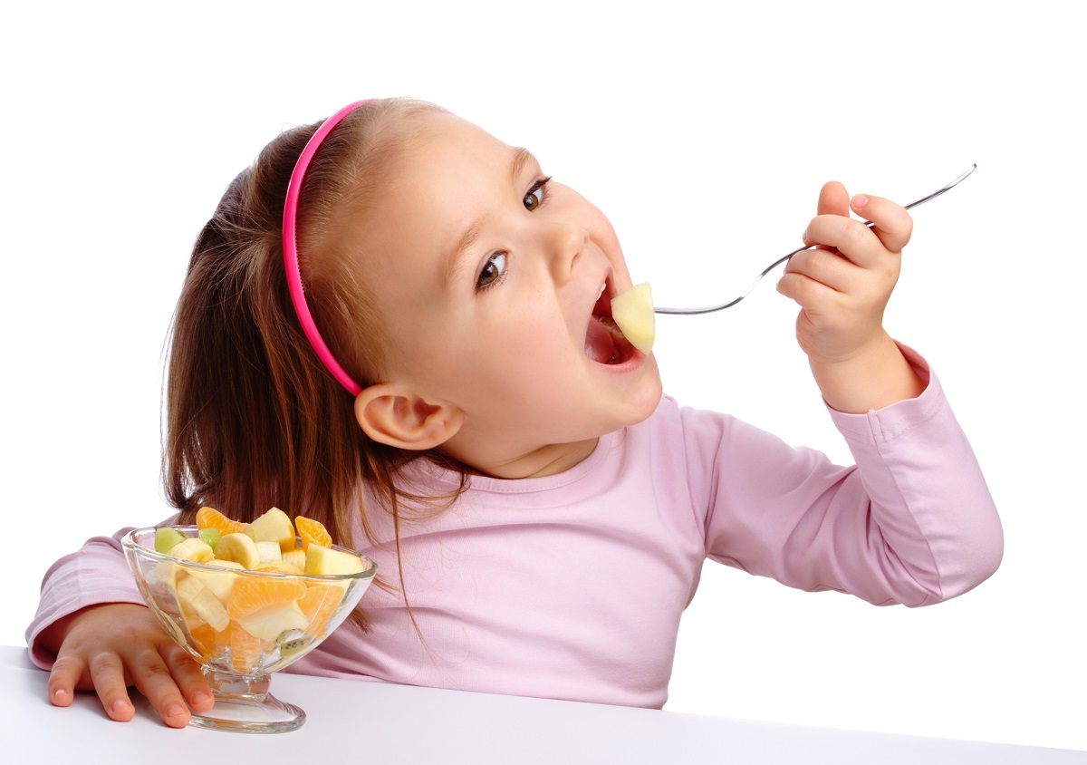 Little girl eats fruit salad