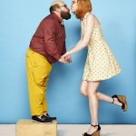 Tall woman and short man kissing